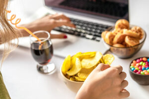 Person eating junk food at a computer