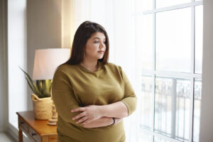 woman looking out the window, depressed