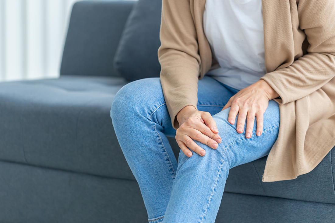 Woman holding painful knee from osteoarthritis